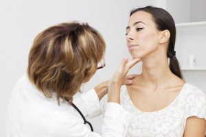 Mature female doctor examining her young female  patient.