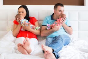 Happy parents cuddling boy and girls twins